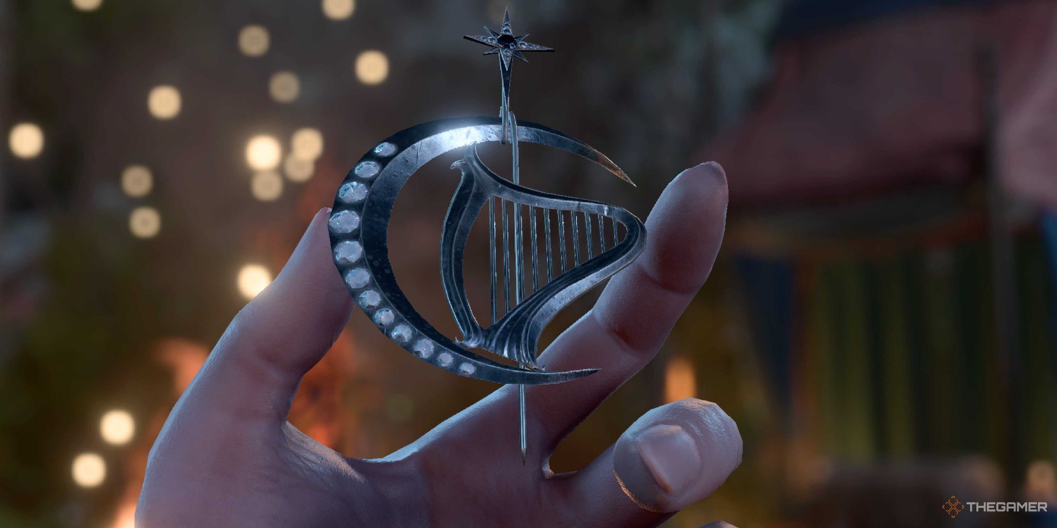 A close up of a hand holding a pin. The pin is silver, and it is in the shape of a crescent moon and a harp.