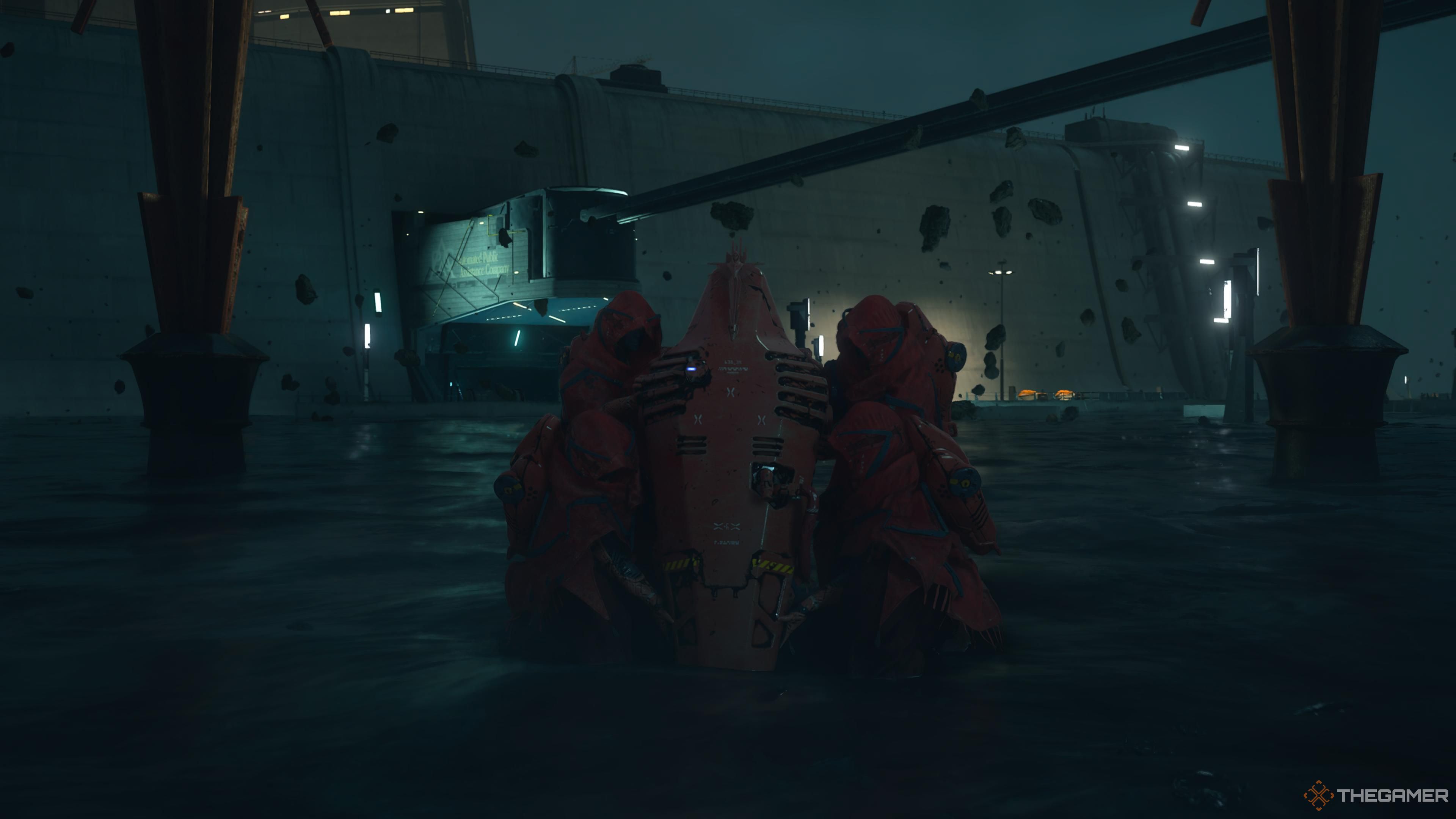 A grouo of people in red robes holding a red coffin in death stranding 2 on the beach.