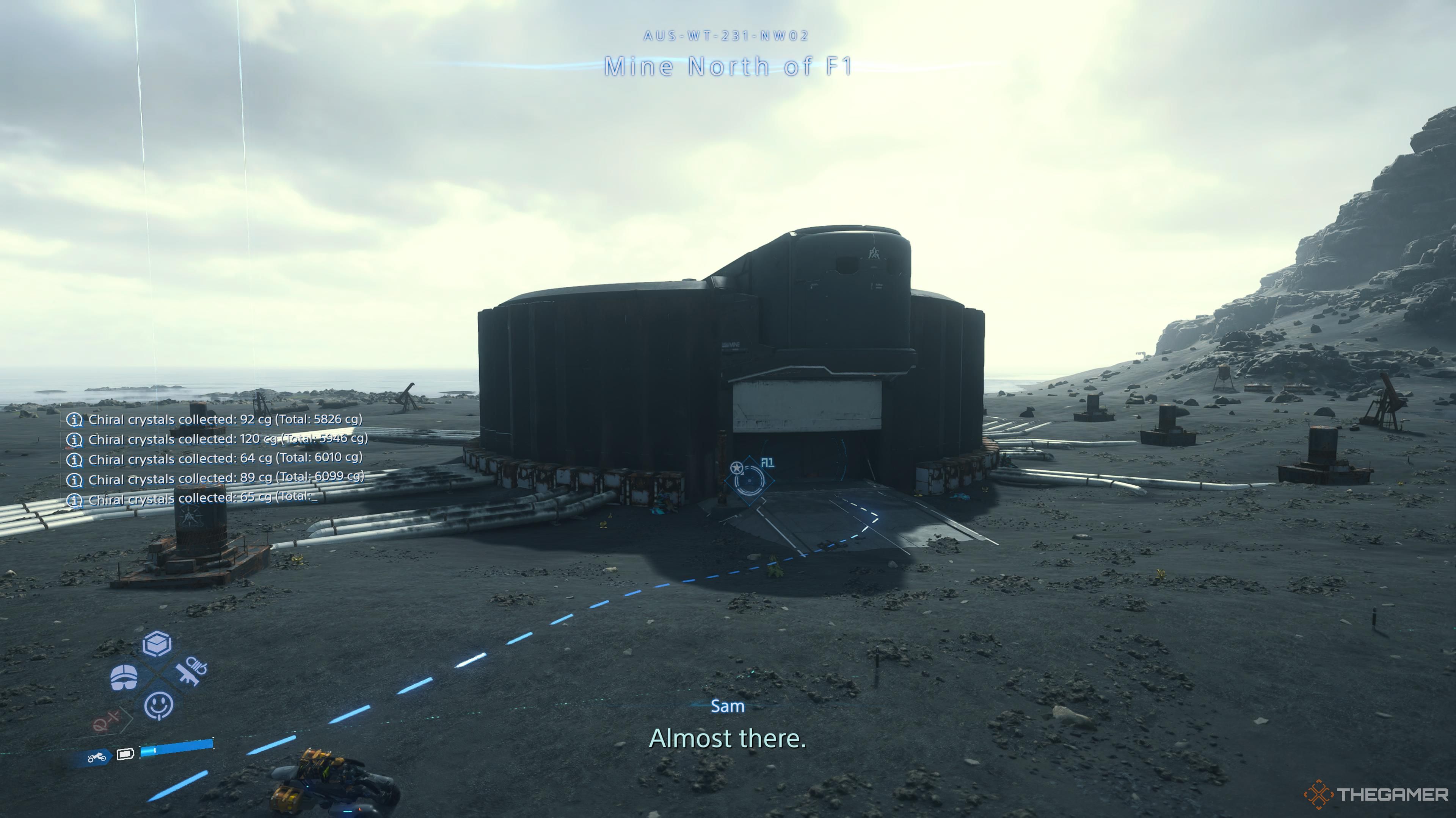 Sam approaching the mine north of F1 in death stranding 2 on the beach.