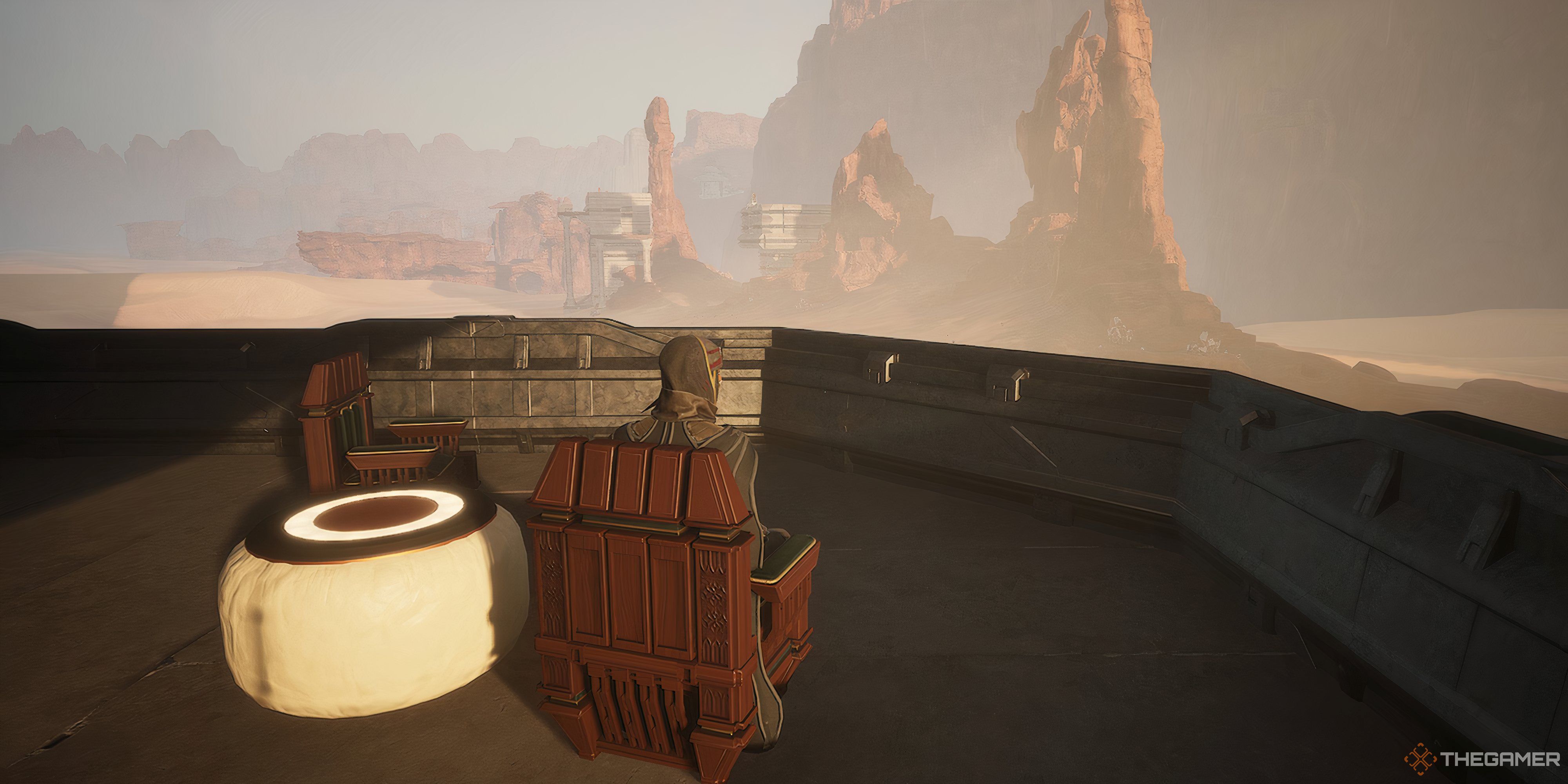 Player sitting on a chair looking onward at other bases in the distance in Dune: Awakening.