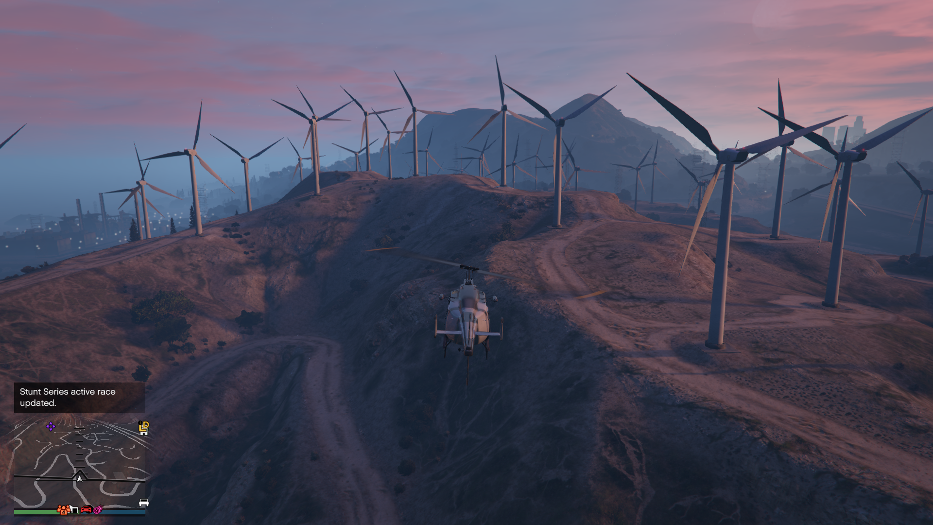 a helicopter flying towards a large windfarm on some hills in gta 5