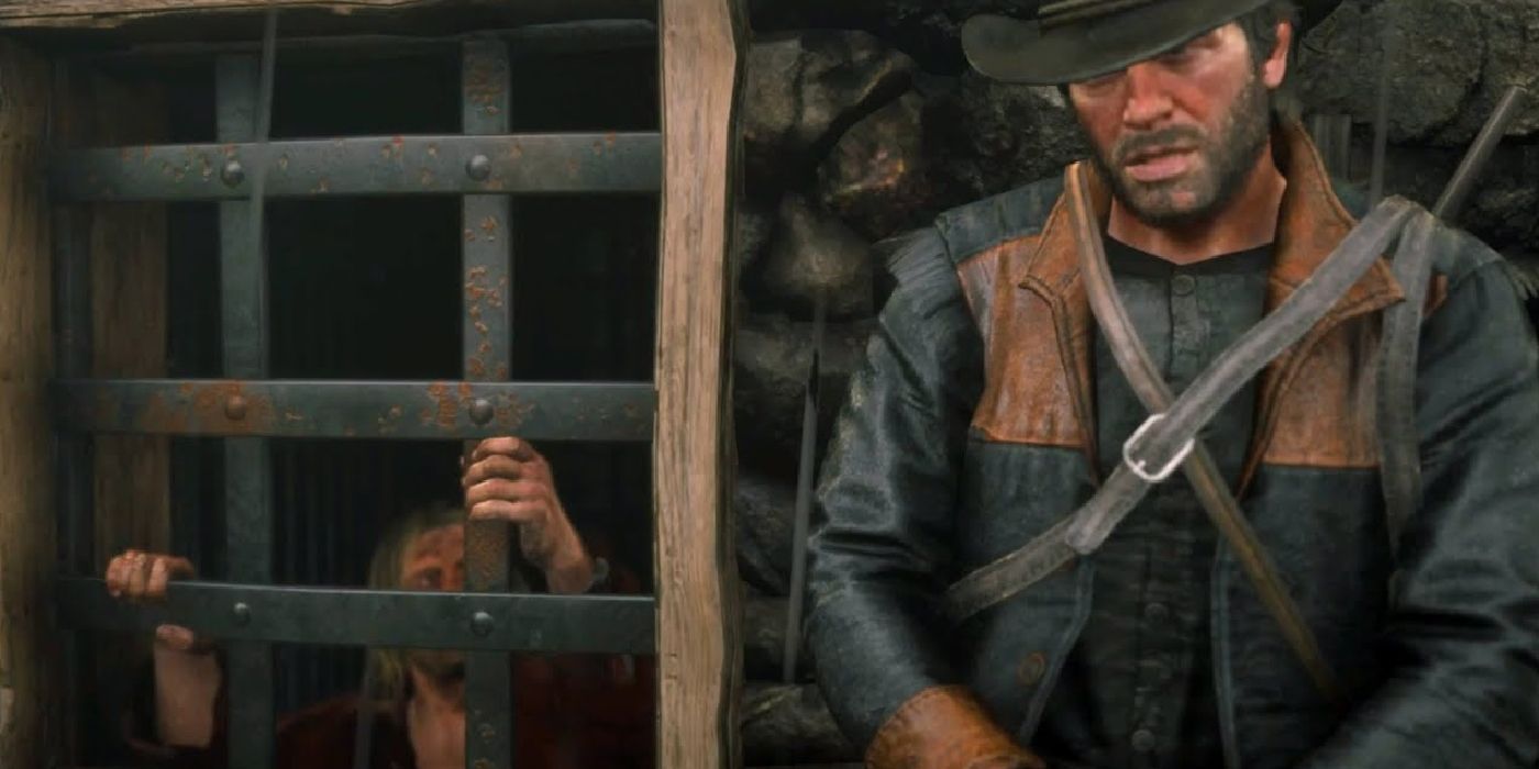 Arthur standing outside the prison cell where Micah is locked up, conversing with him.