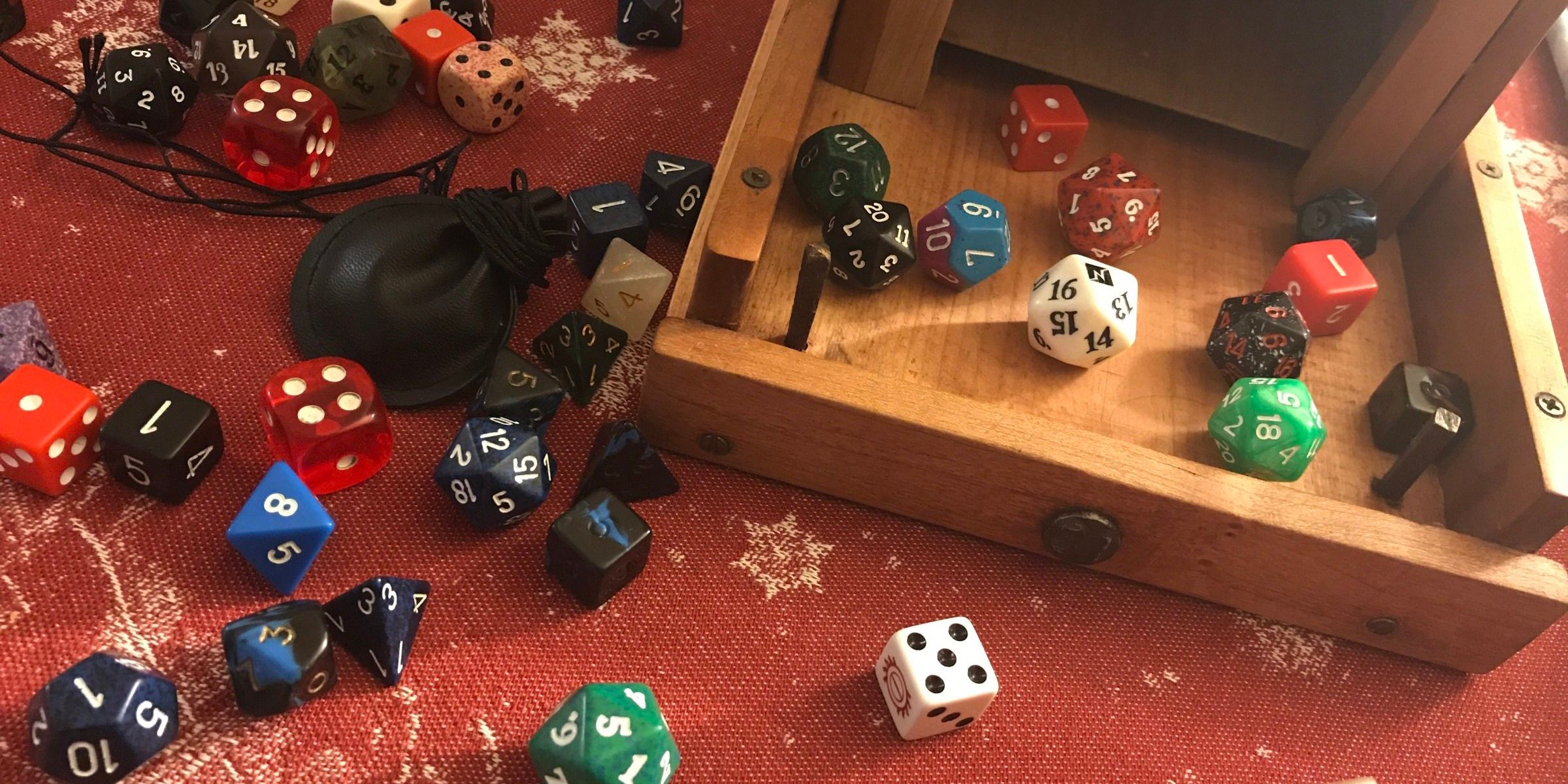 multisided dice of various colors, open wooden box