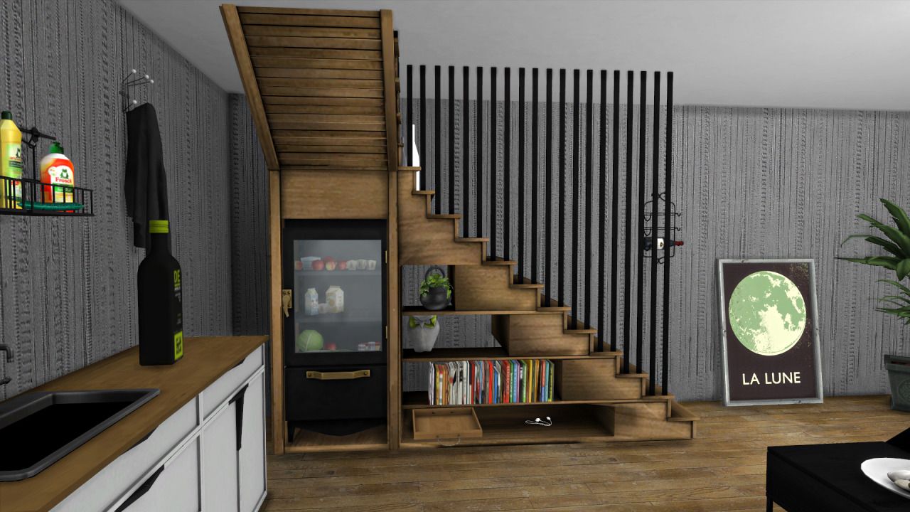 A right angled staircase with bookshelves and a fridge underneath it.