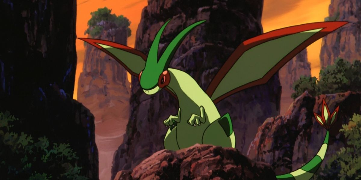 A Flygon stands on a rock in the Pokemon anime.