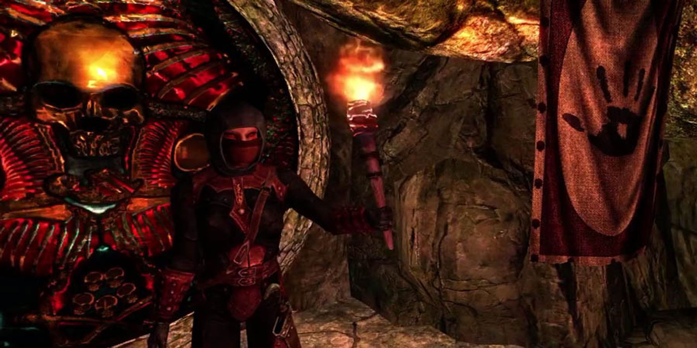 Skyrim: An assassin from the Dark Brotherhood guards a door, torch in hand