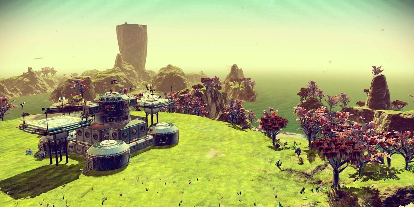 A base surrounded by green grass and red trees in No Man's Sky