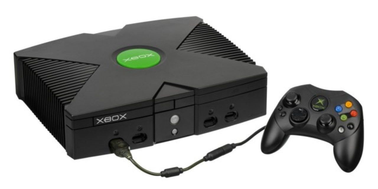 Image of the original Xbox with a controller connected to it. 