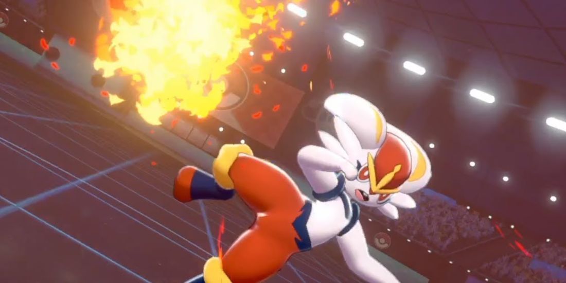 The Pokemon Cinderace firing off a Pyro Ball attack in a stadium of cheering fans.