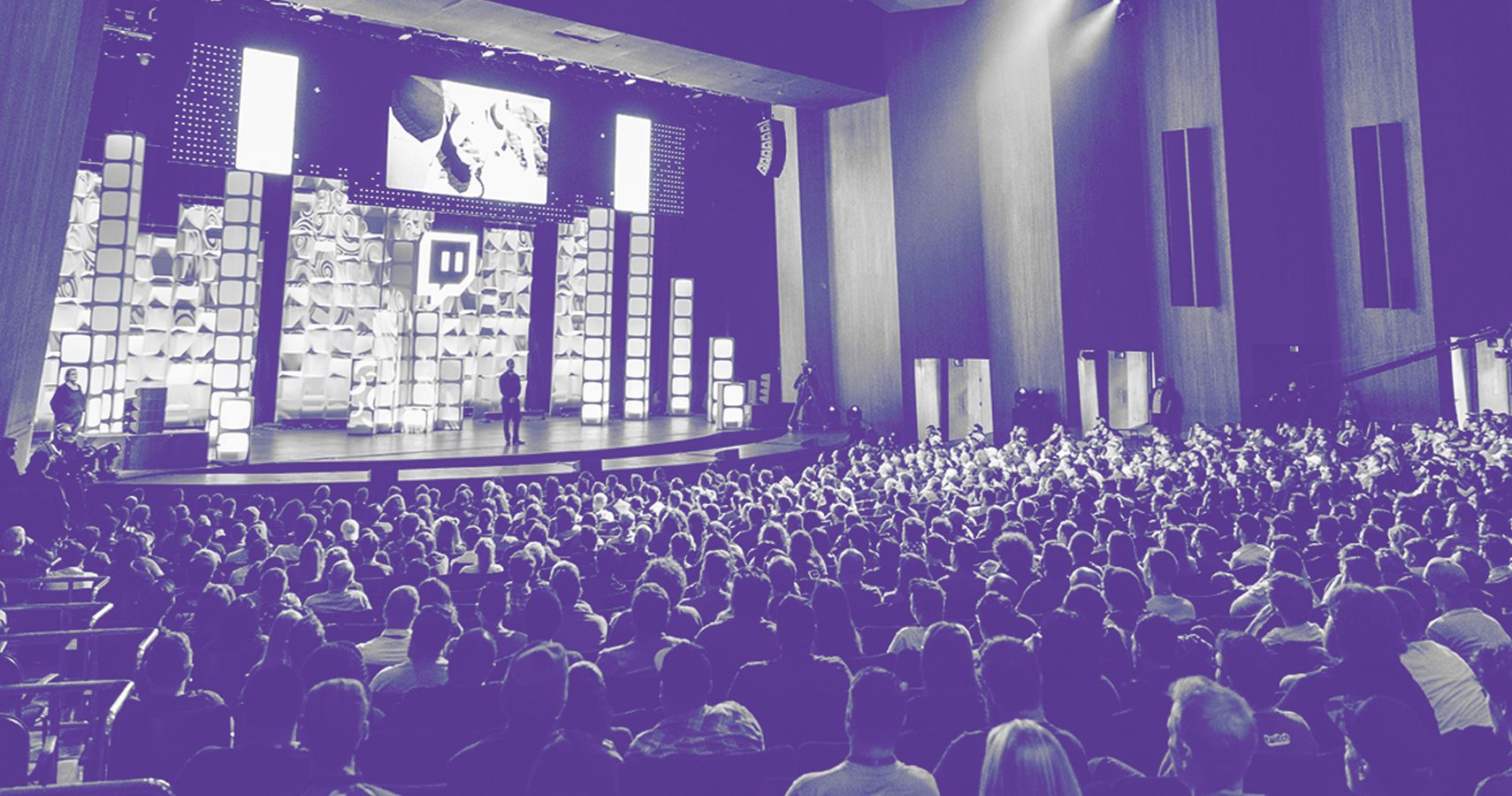 A purple-tinted image of the audience at a Twitch event.