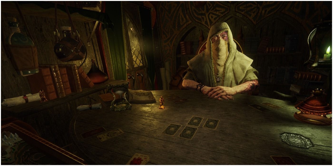 The card dealer sitting at a stable with cards on it.