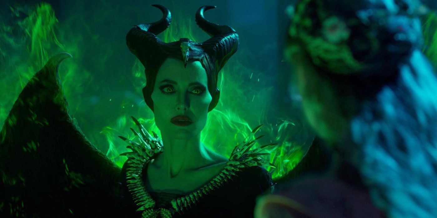 Aurora and Maleficent confront the green flames spouting from Maleficent's back.