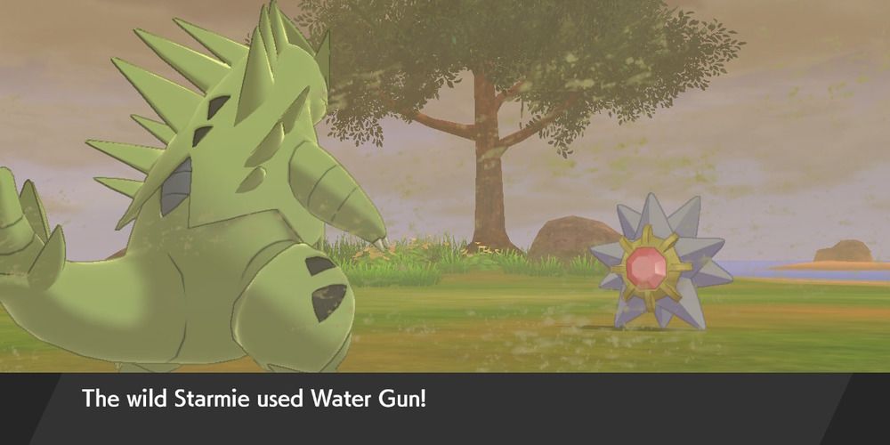 Pokemon Shield Starmie attacking with Water Gun on Tyranitar