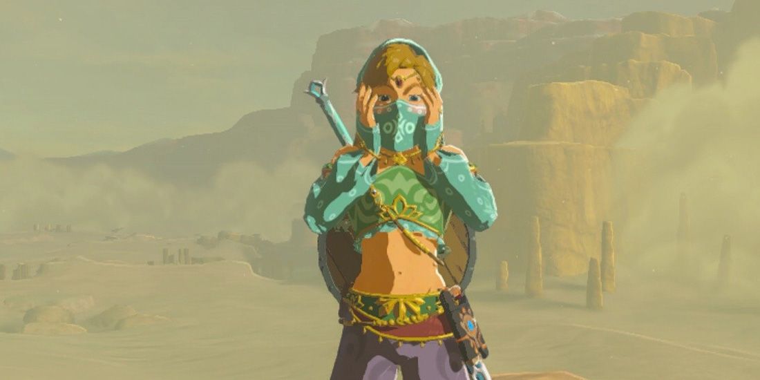 Link wearing the Gerudo outfit with his hands on his face in Breath of the Wild