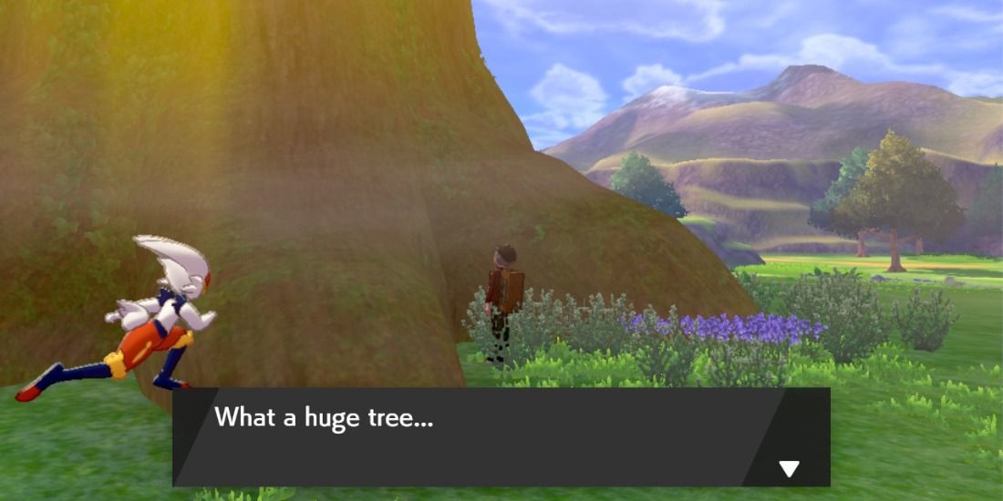 Trainer shaking the Dyna Tree in Pokémon Sword & Shield's Crown Tundra area