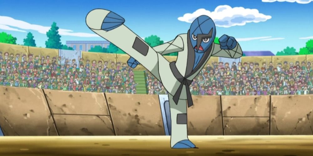 Sawk from the Pokemon anime stands on one leg, kicking the air inside an arena.