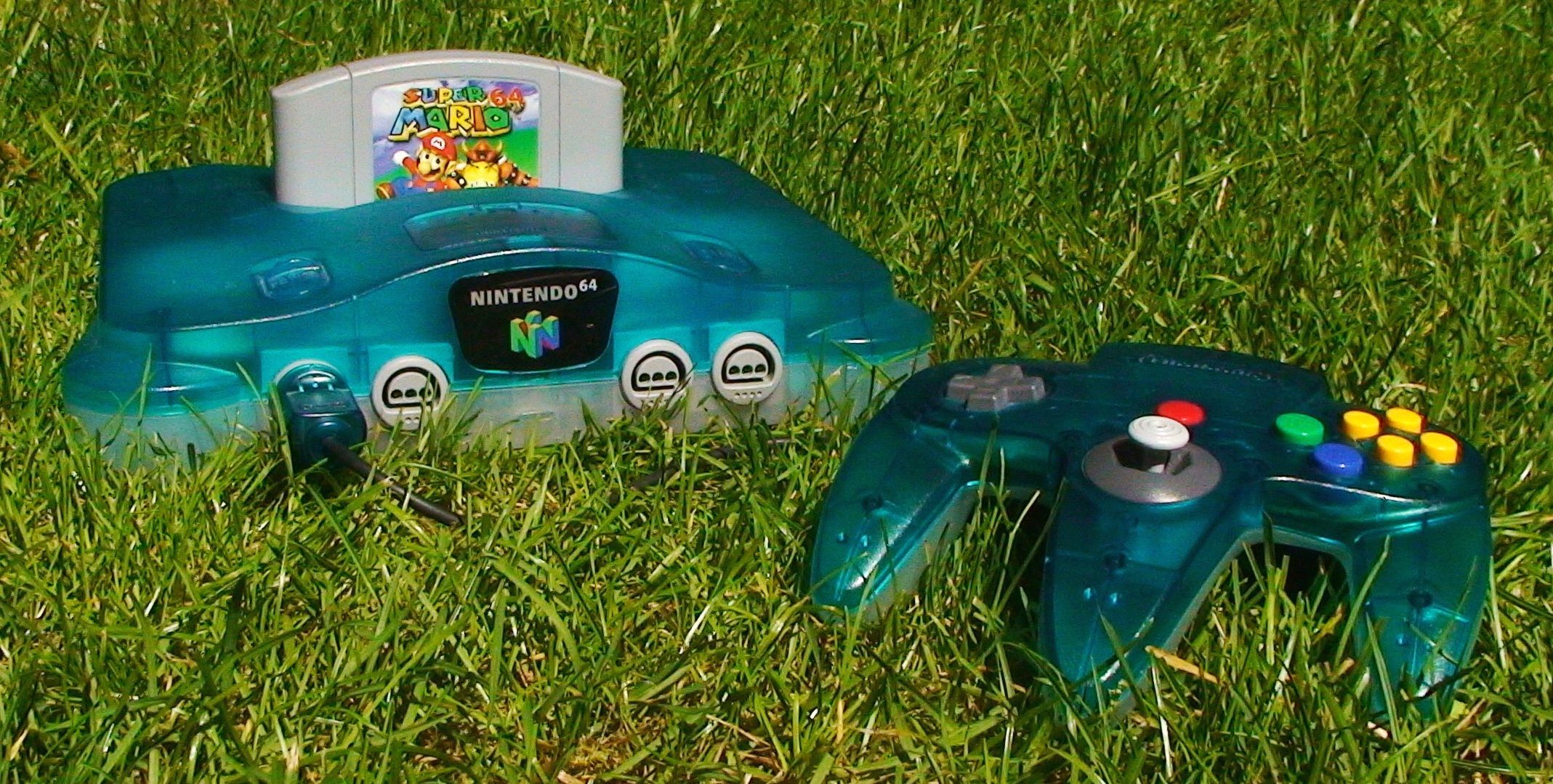 A blue translucent N64 console in the grass.