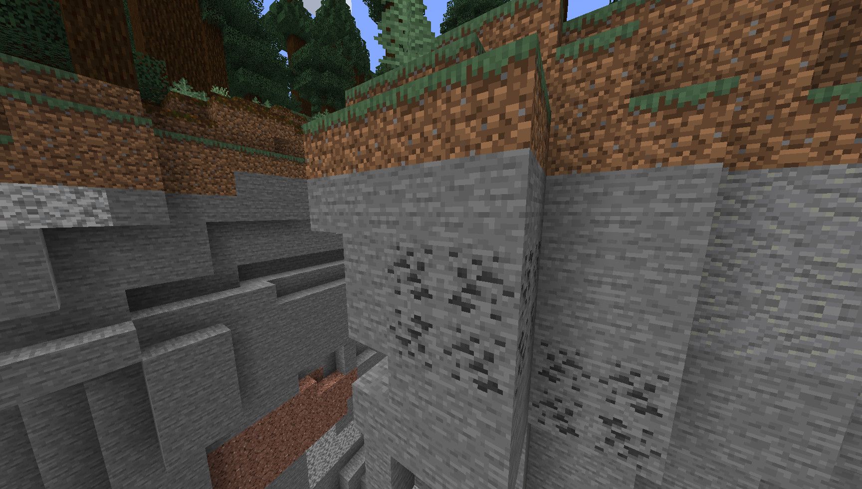 a cliff face in minecraft with some visible coal ore