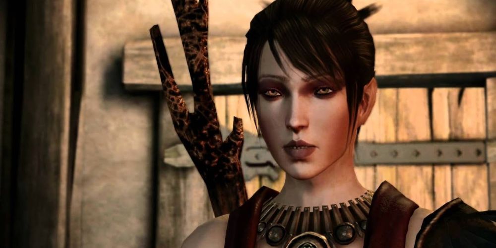 Close up on a human woman's face in a video game, with raven black hair carrying a staff.