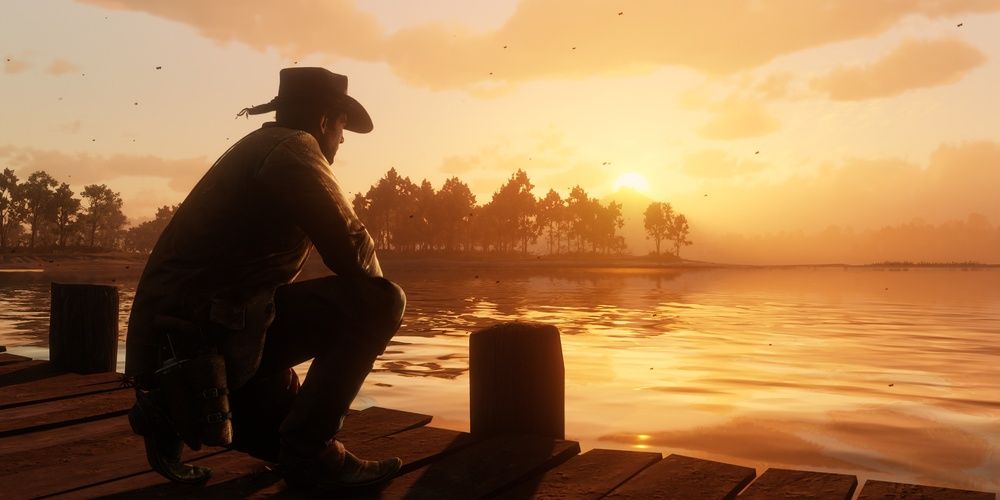 Arthur Morgan crouched on a dock in Red Dead Redemption 2