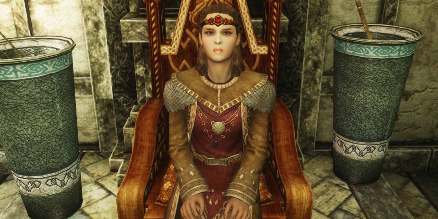 A well-dressed ruler looks up at the camera from a wooden throne.
