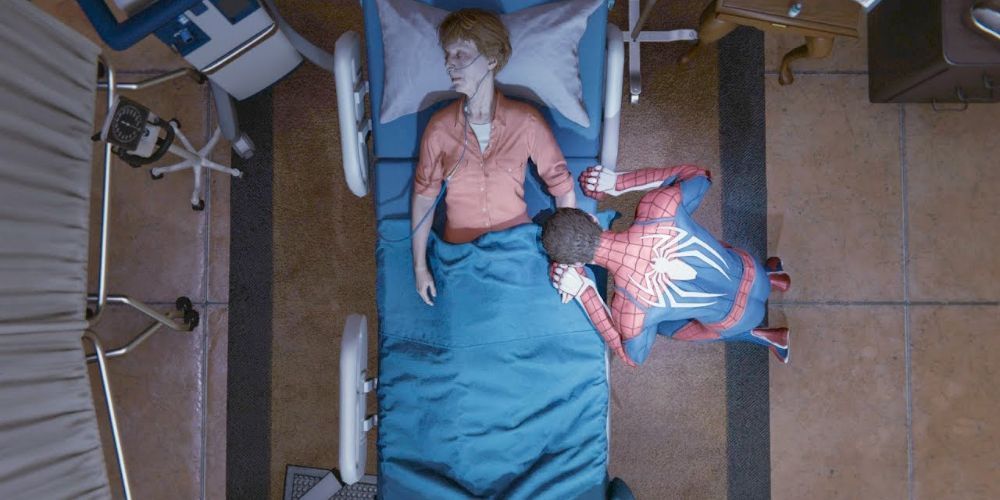 Peter Parker in Spider-Man costume holding May's hand and grieving over her death as she lies on the hospital bed.