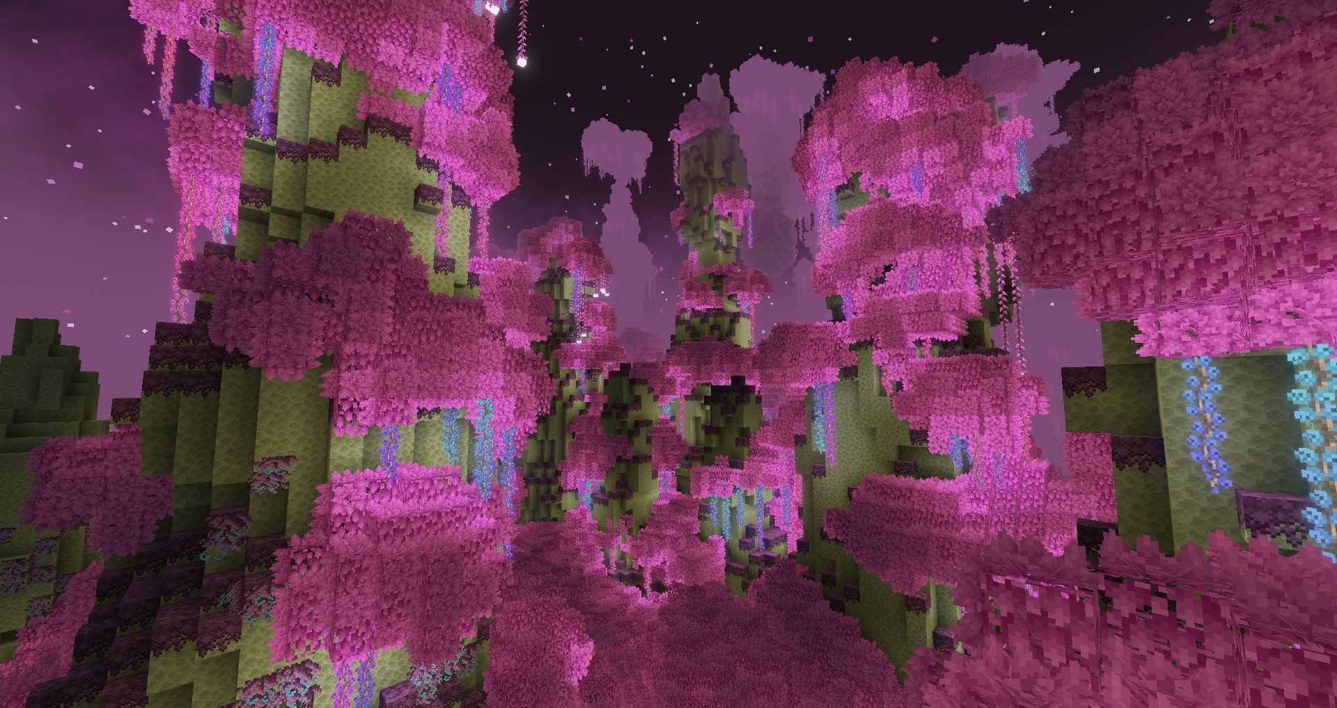 A scenic screenshot of a new biome in The End, with towering hills of pink trees and glowing blossoms that hang from them.