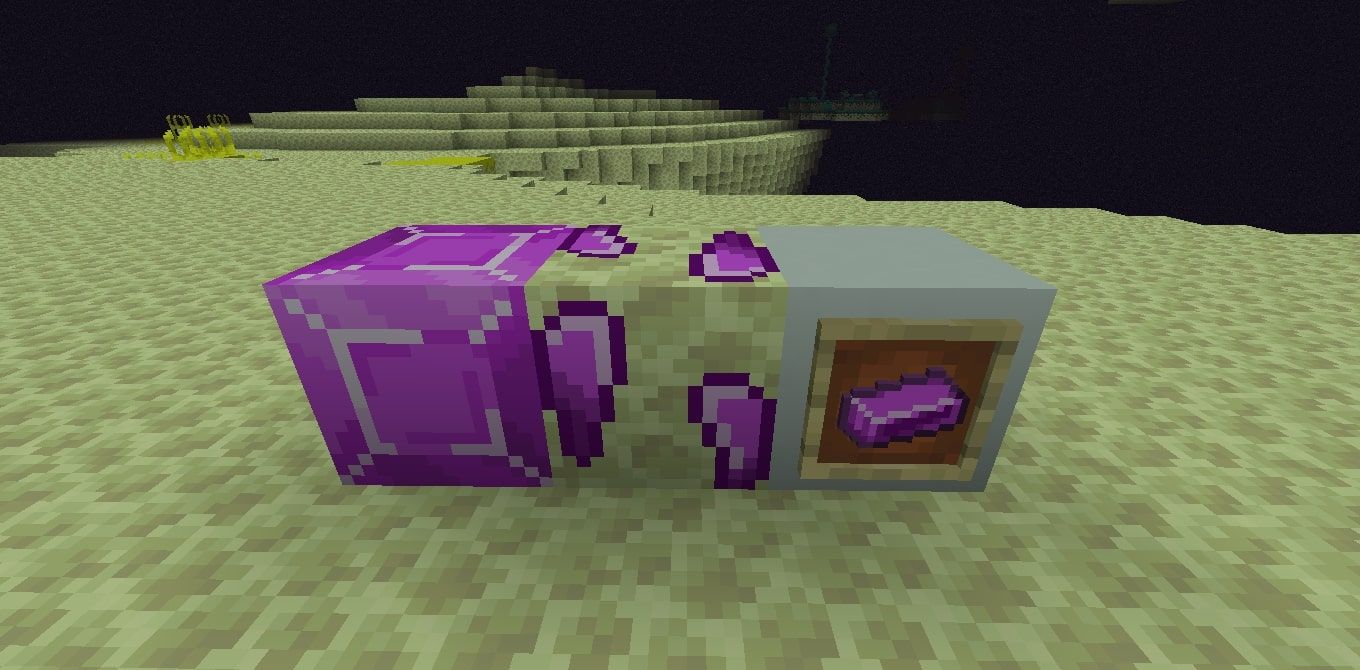 An image of three Minecraft blocks in The End, one made of solid Enderite, a block of naturally-occuring enderite ore, and a block with a frame placed on it, with an enderite ingot in the frame.