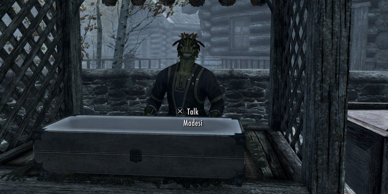 A lizard-like argonian stands at his stall, with jewelry locked inside a glass case.