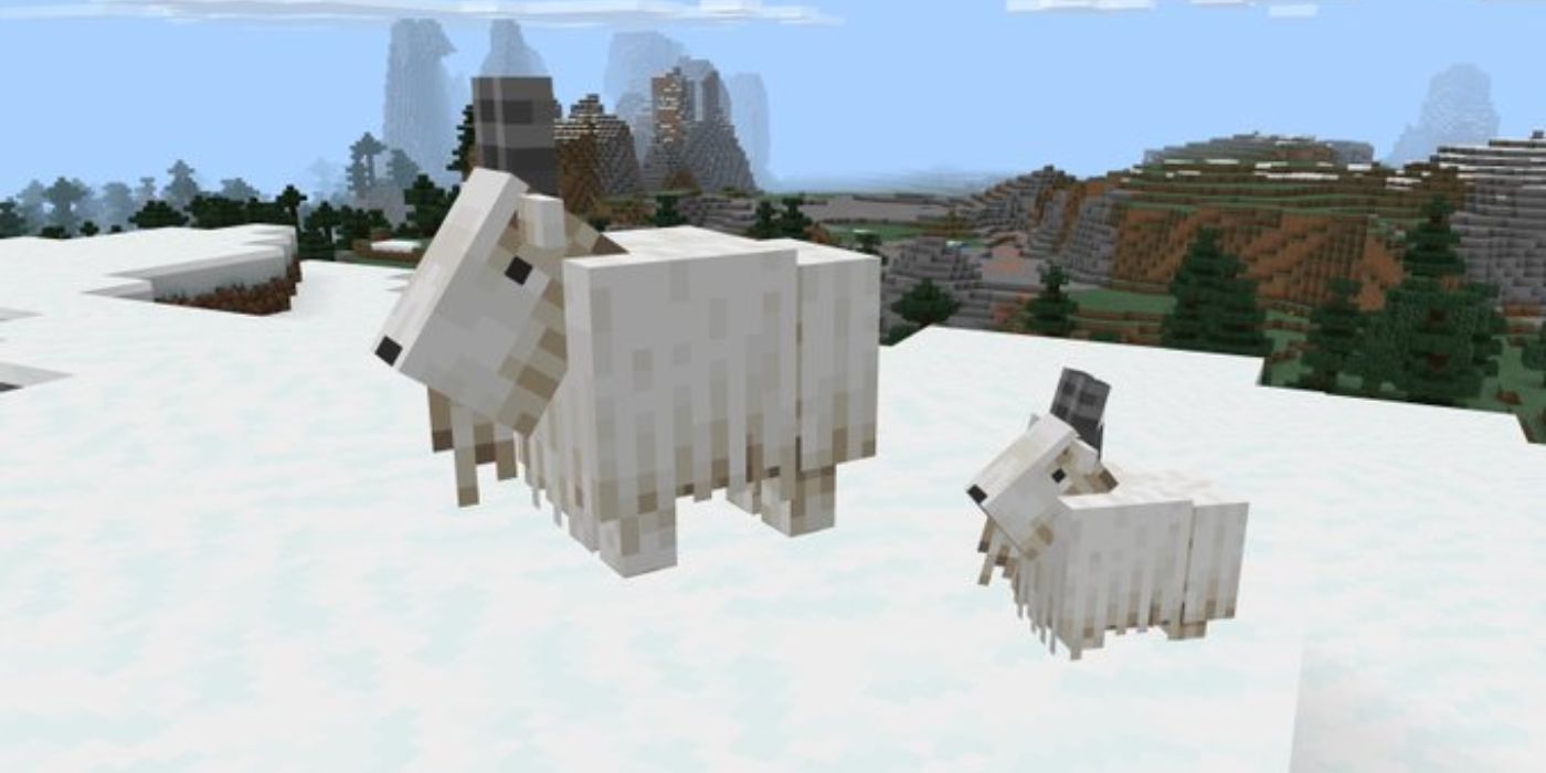 Minecraft adult and baby goat side by side on top of a snow-covered mountain.