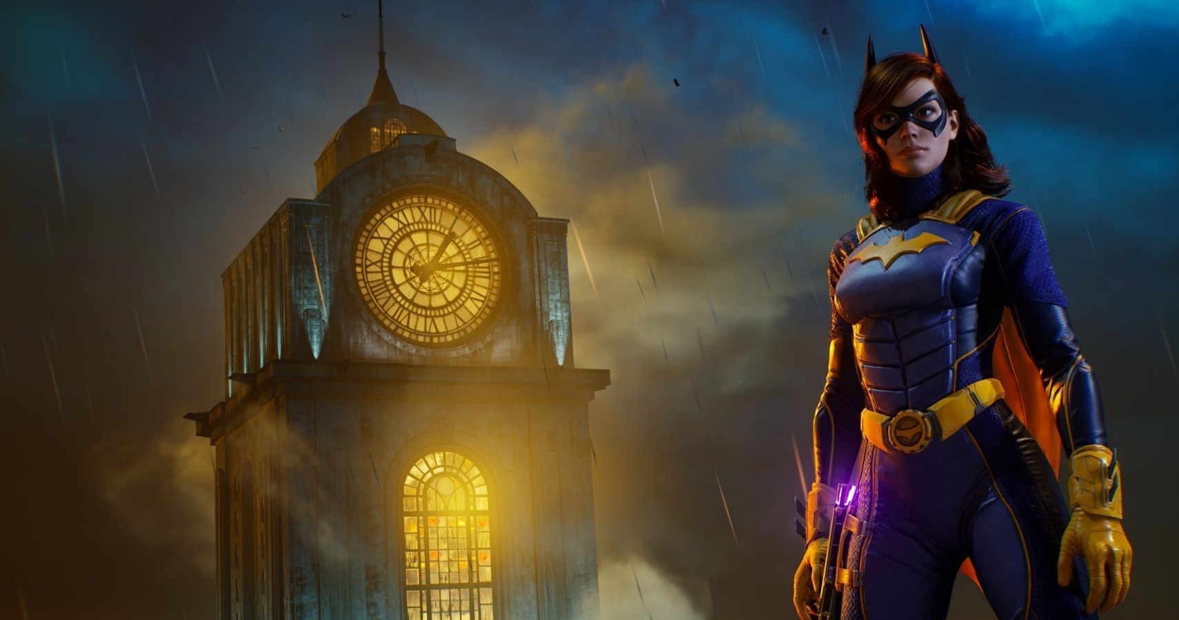 Batgirl stands in a black and yellow superhero costume. She is standing outside in a city, on a misty night.