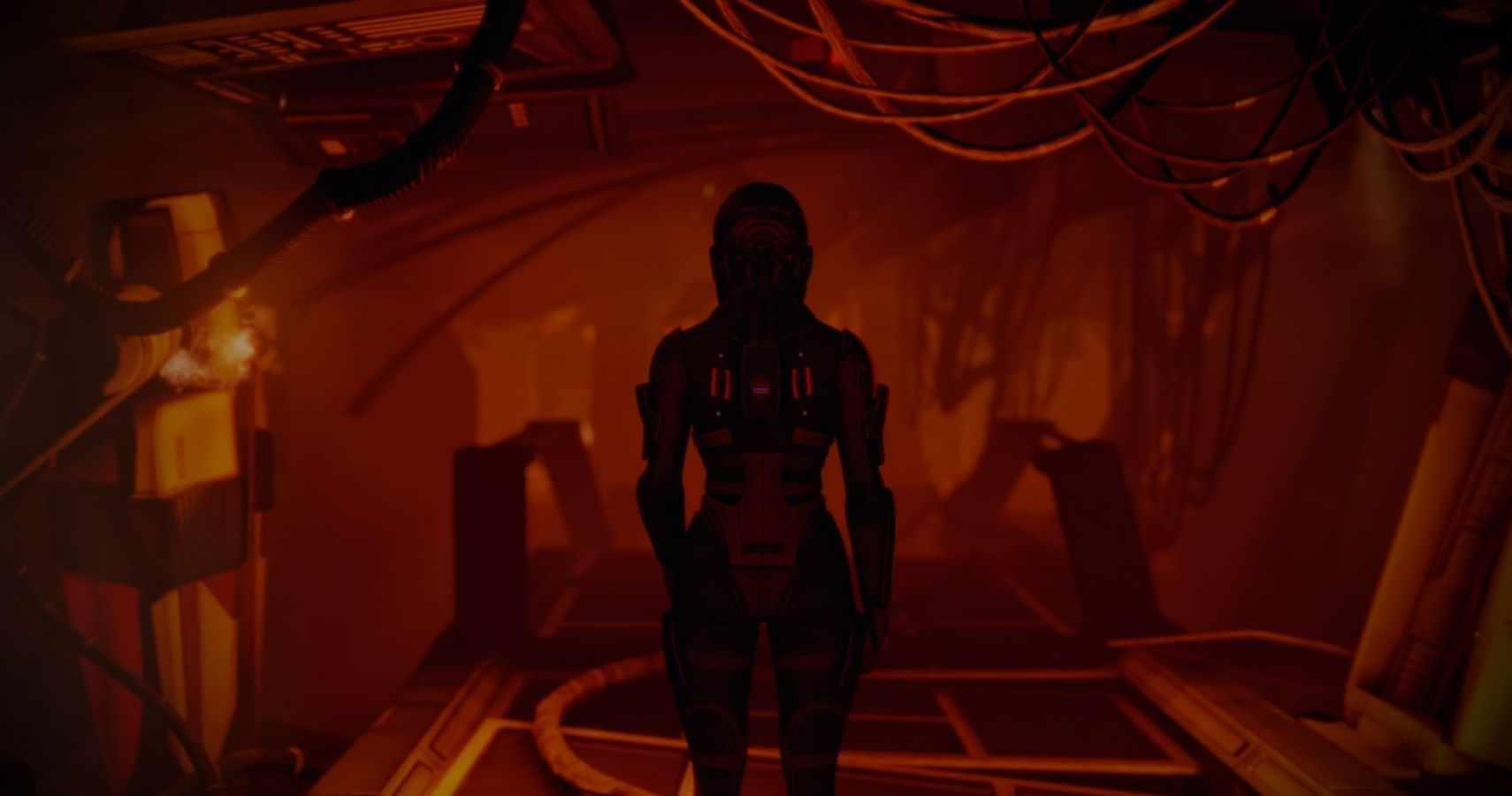 Commander Shepard, a solider, is in a space suit, standing in space ship that is under attack