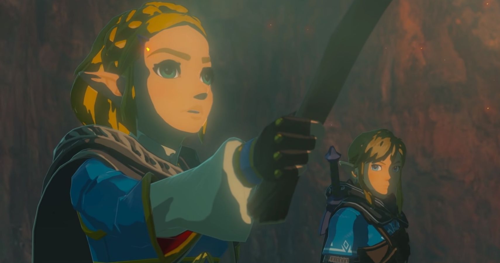 Zelda stands in front of Link. Both have blonde hair and wear blue clothing. They appear to be travelling.