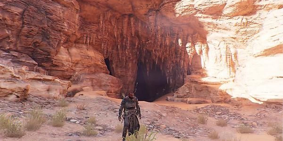 AC Origins a player outside a large cave