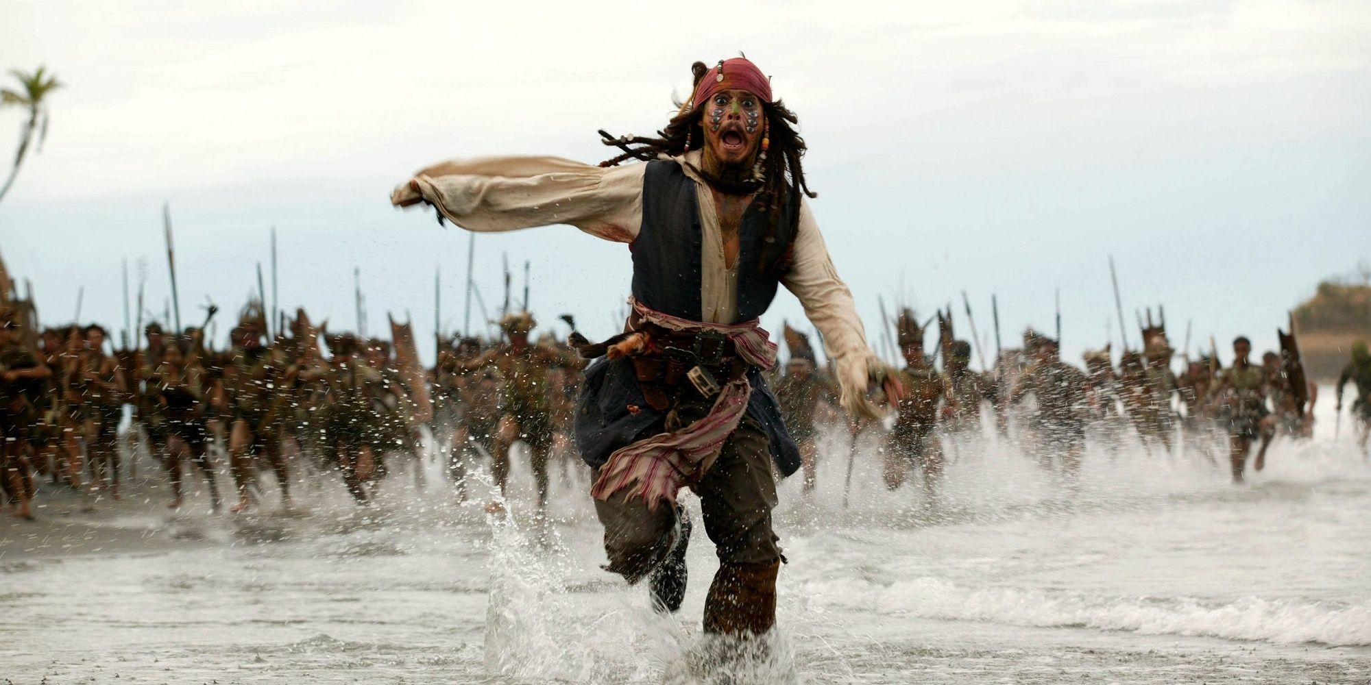 Captain Jack Sparrow running from tribal warriors on a beach