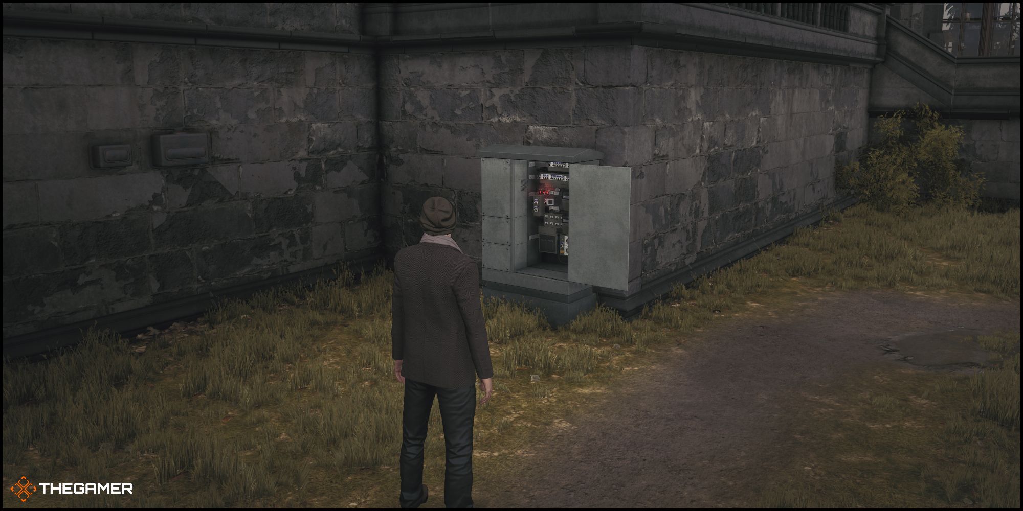 Agent 47 standing in front of a fusebox in Hitman 3