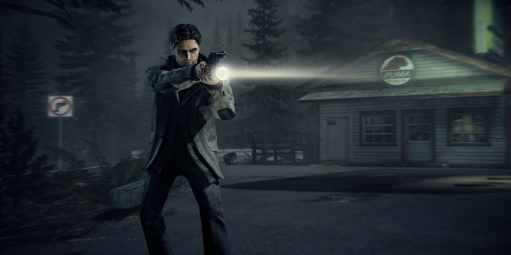 Alan wake stands outside a store in a dark forest holding a flashlight and gun