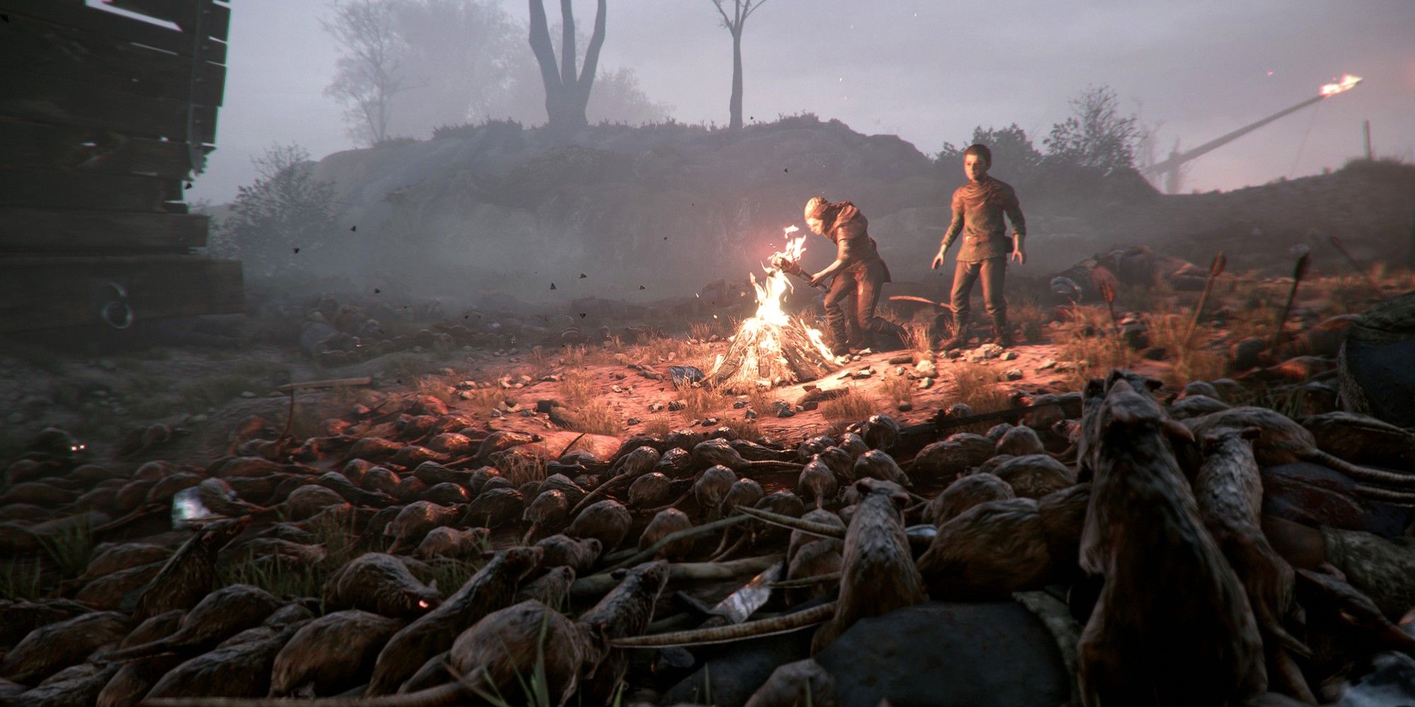 The two protagonists fending off a rat horde in A Plague Tale
