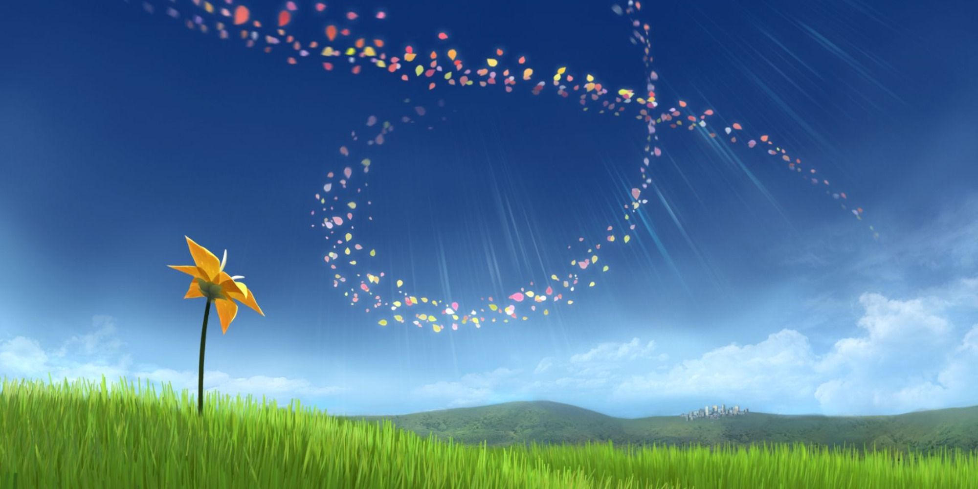 grassy area and clear blue sky with a single flower bottom left and petals swirling above