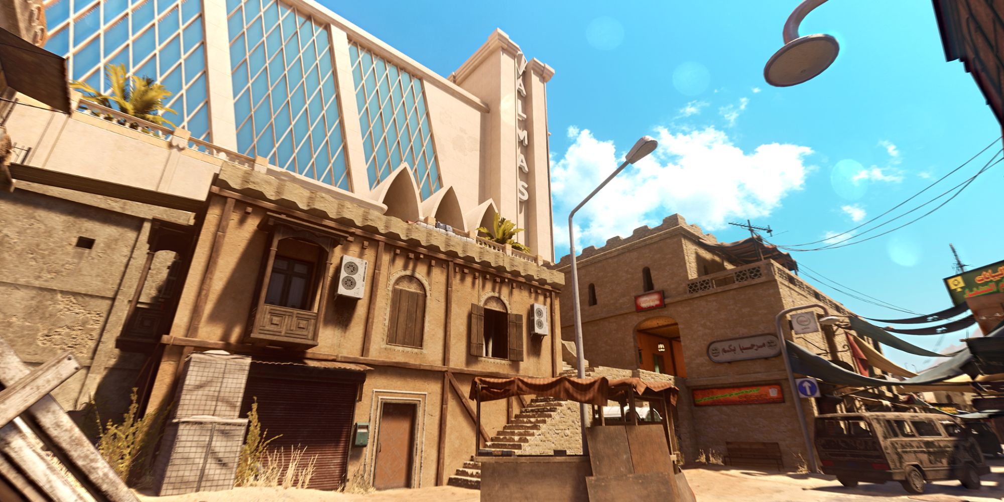 Insurgency Sandstorm Maps a wide shot of the map Gap with small, impoverished homes in the foreground against a towering hotel with a wall of glass windows in the background