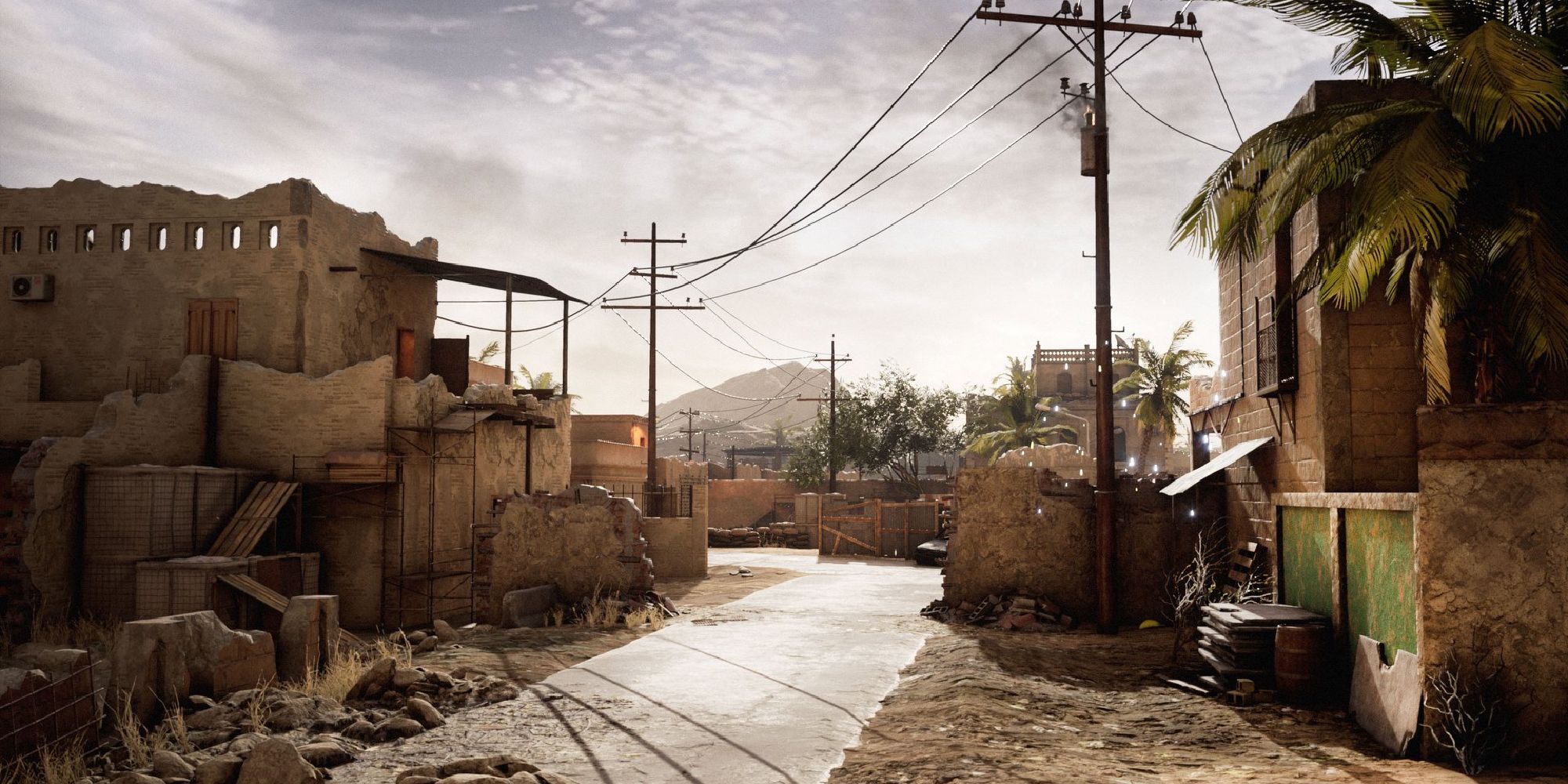 Insurgency Sandstorm Maps a wide shot of the map Hideout with a concrete alleyway leading up to distant ruined buildings and a telephone line stretching from the foreground to the background