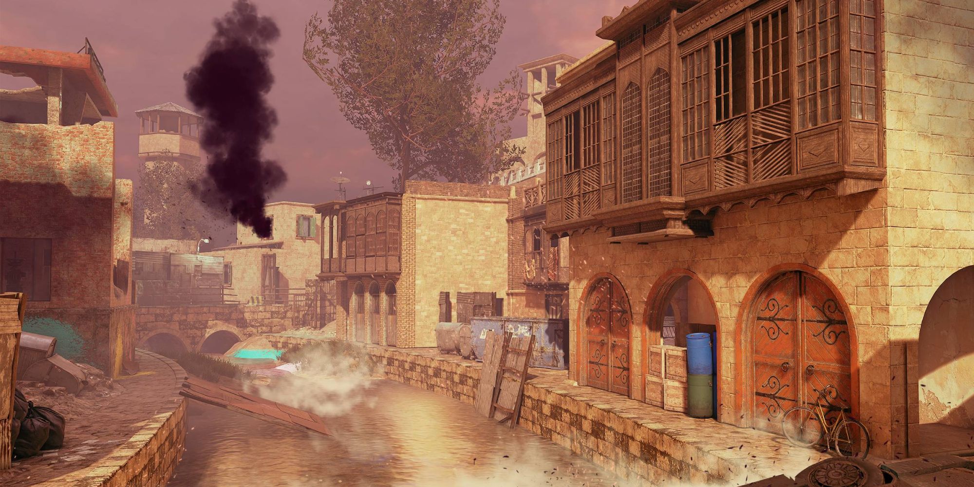 Insurgency Sandstorm Maps a mid shot of the map Tell with a river running in between two lines of buildings with smoke billowing in the distance
