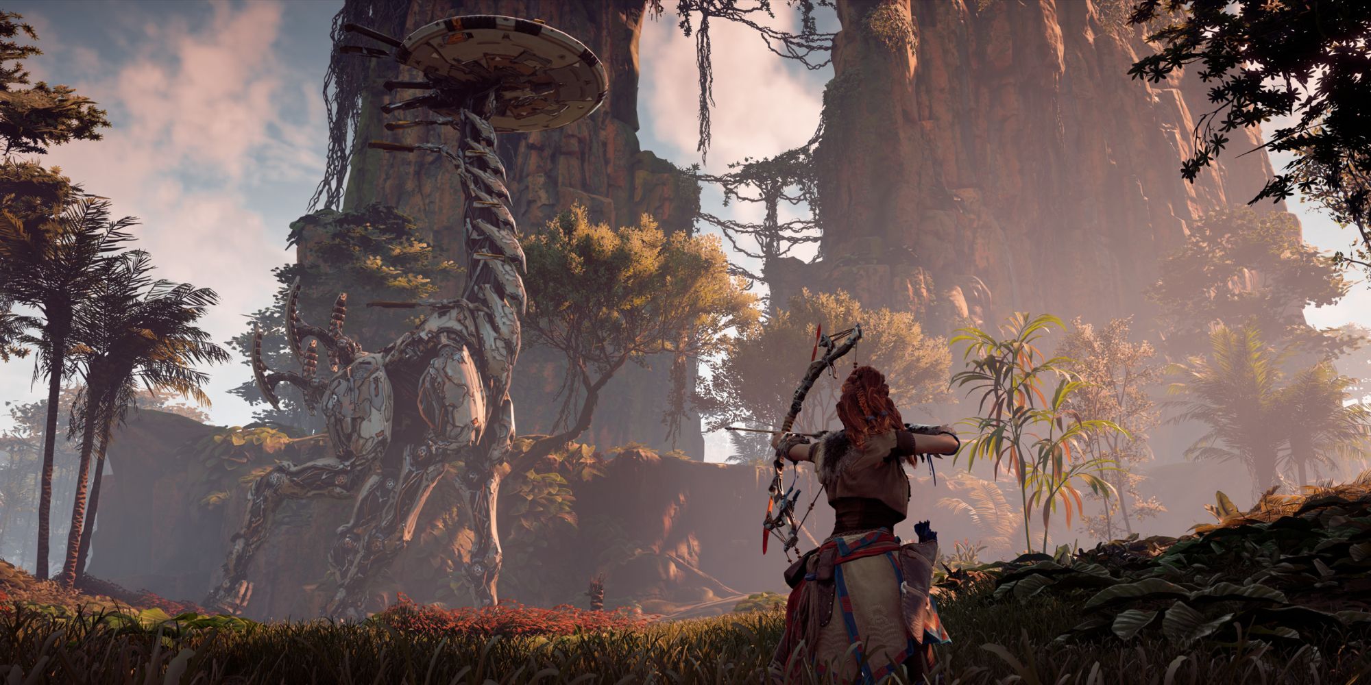 Robots In Video Games a wide shot of the female protagonist of Horizon Zero Dawn Aloy aiming her bow at a distant towering Tallneck which is walking against a backdrop of mountains and trees