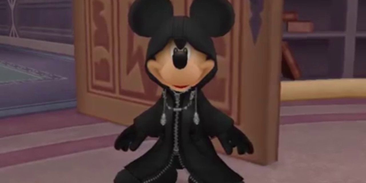 Mickey Mouse stands in the room in black robes and a smile