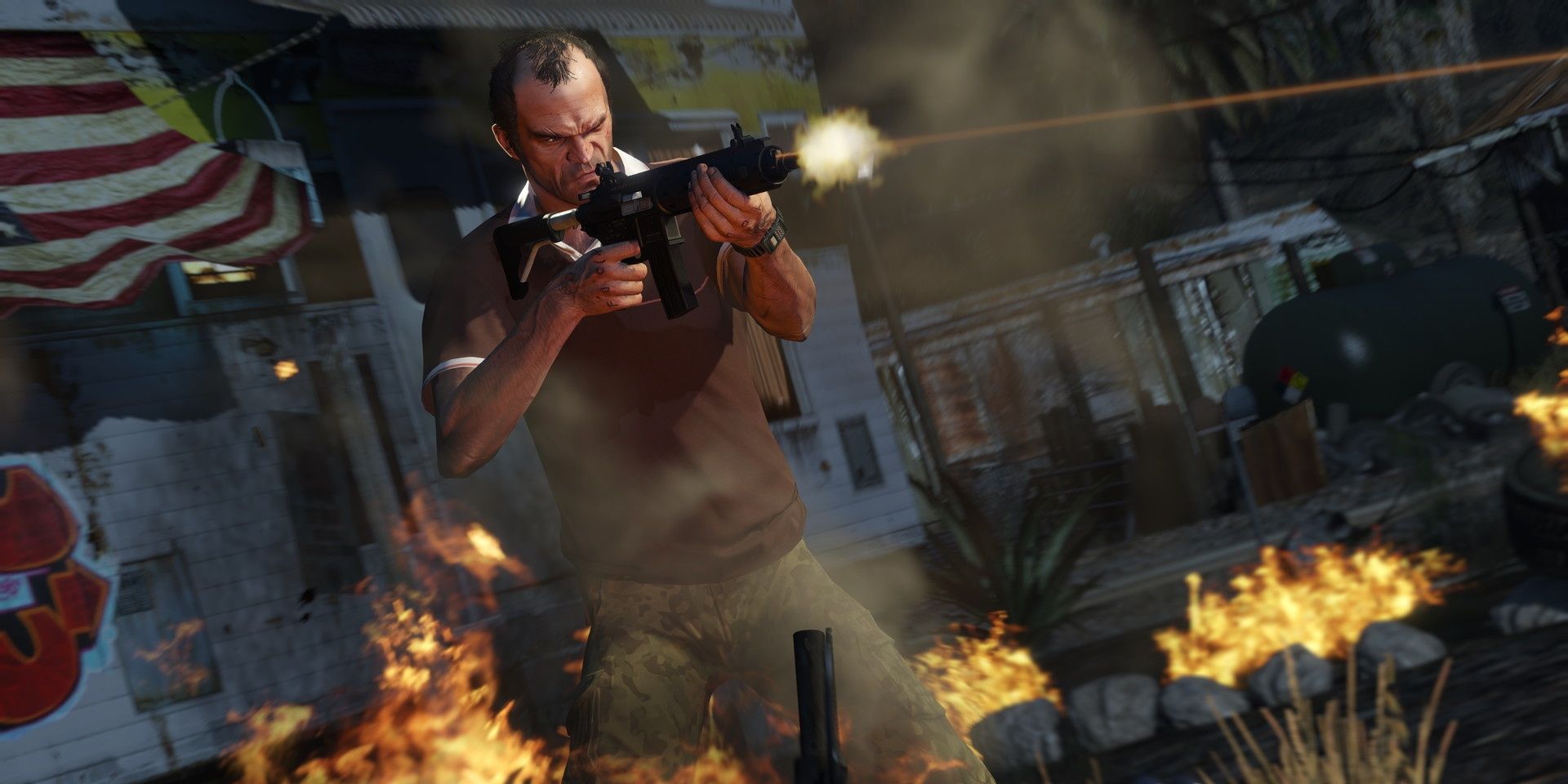 A screenshot showing Trevor shooting a machine gun amidst flames in Grand Theft Auto 5