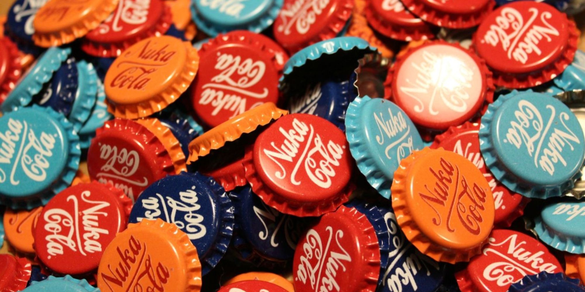 Fictional Currencies a collection of red, blue and orange Nuka Cola bottle caps from Fallout