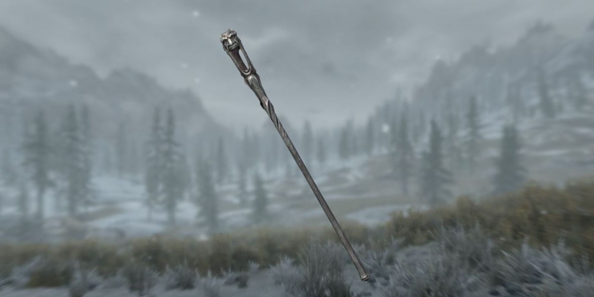 A screenshot showing the Wabbajack, a long staff made of black metal and decorated with a grotesque grinning face.
