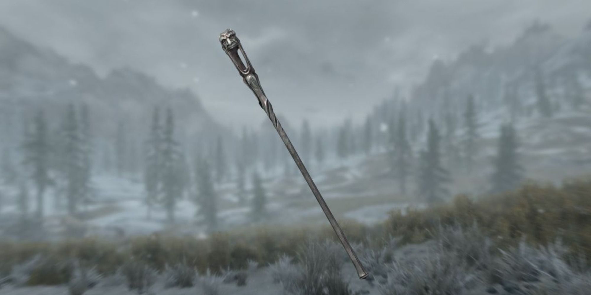 A screenshot showing the Wabbajack, a long staff made of black metal and adorned with grotesquely laughing faces.