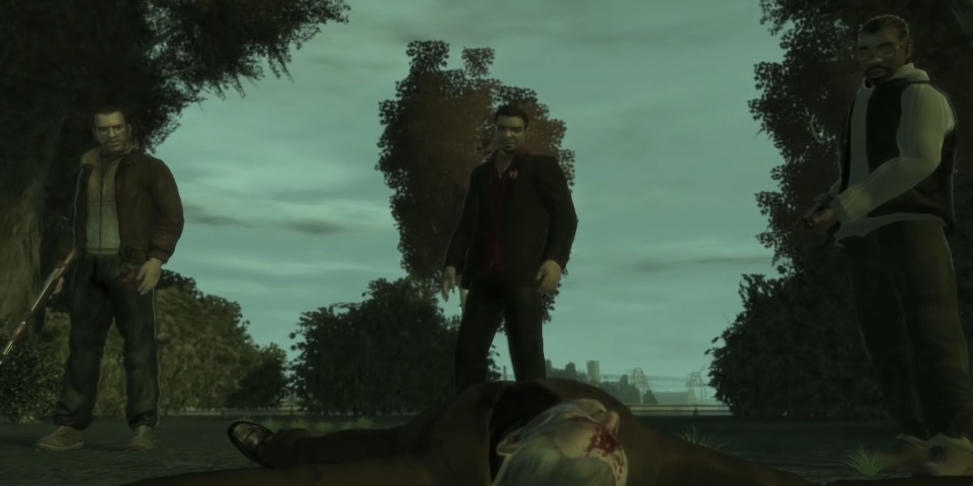 A screenshot showing Niko, Roman and Jacob standing over Jimmy Pegorino's body in Grand Theft Auto 4