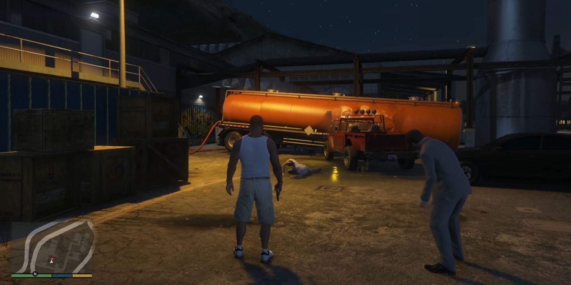Franklin and Michael standing in front of a wounded Trevor in Grand Theft Auto 5